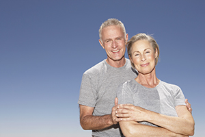 Mature couple stop on the beach to look out at the ocean
