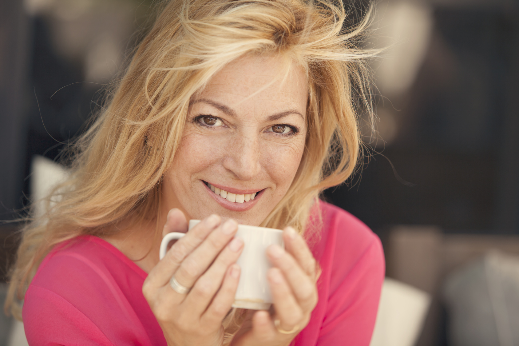 woman drinking a cup of coffee outside