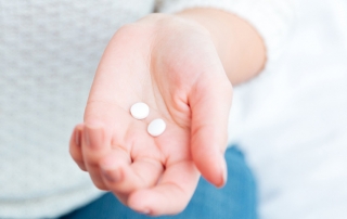 Female hands holding pills
