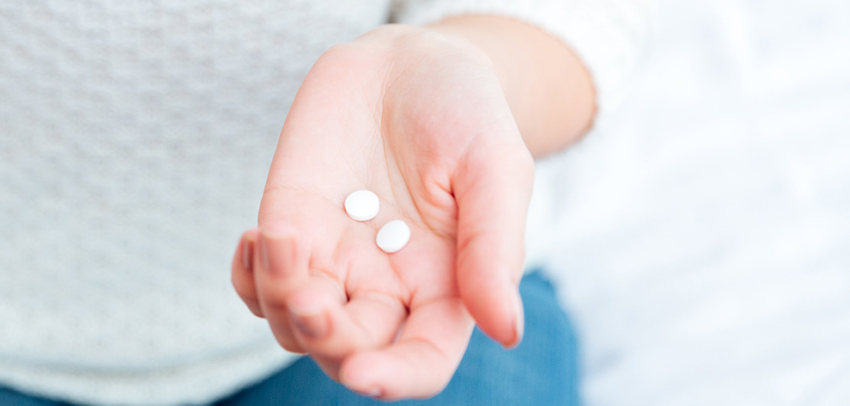 Female hands holding pills