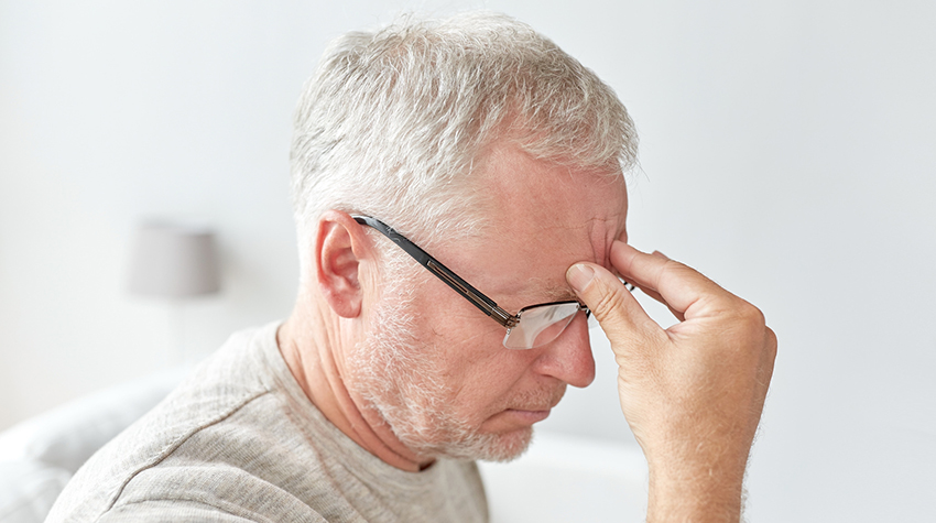 senior man suffering from headache at home