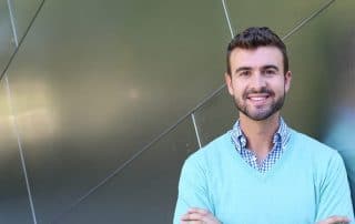 man in sweater vest shows off his strong jaw line & smile