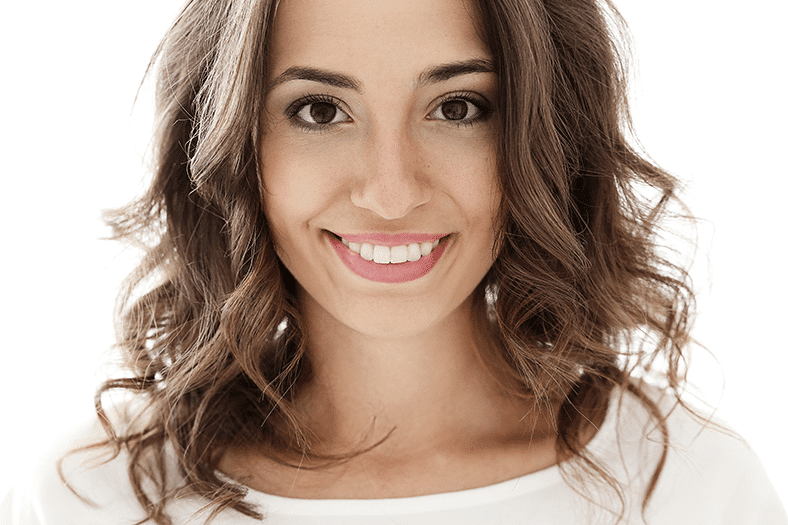 Pretty brunette haired woman shows off he amazing smile. You'd never know it, but she use to suffer from Oligodontia, a condition where multiple teeth fail to develop in a person’s mouth