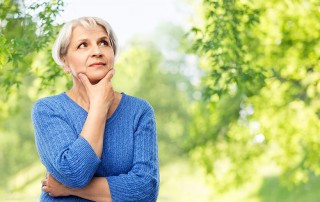 Older woman pondering questions while taking a walk in the park