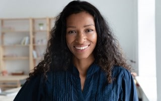Woman with black curly hair shows off her amazing smile