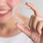 female hands shows off her Invisalign clear braces