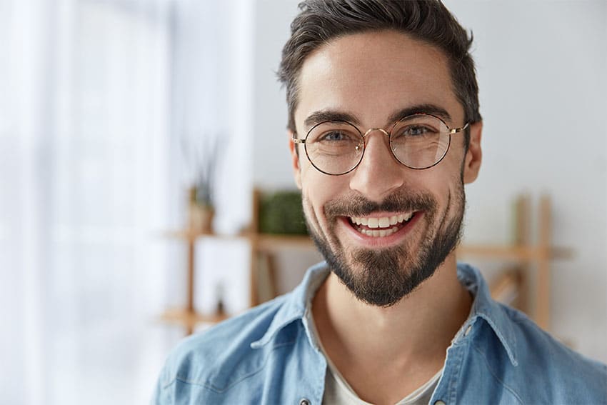 man in oversized glasses and beard shows off his amazing smile